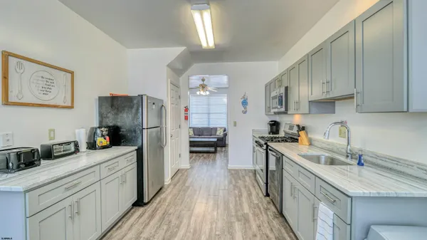 a kitchen with a sink a refrigerator and cabinets