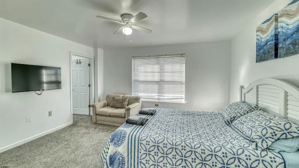 a bedroom with a large bed and a flat screen tv