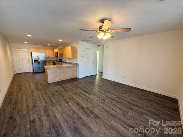 a view of a room with wooden floor and ceiling fan