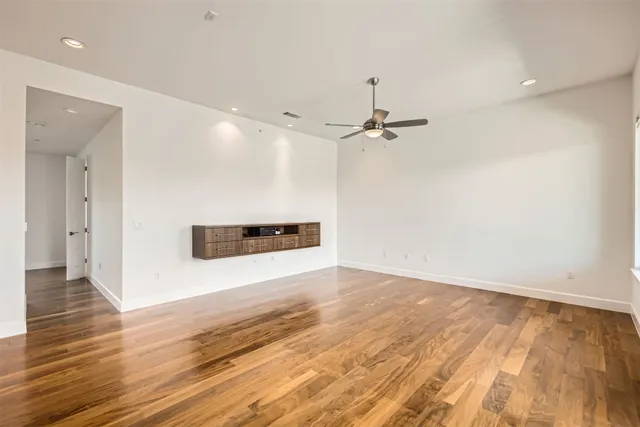 a spacious bedroom with a bed and a wooden floor