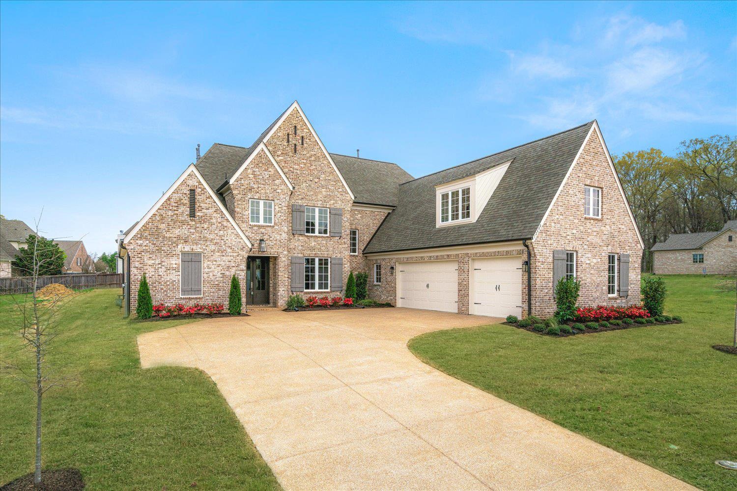 View of front of property with a shingled roof, driveway, an attached garage, and brick siding