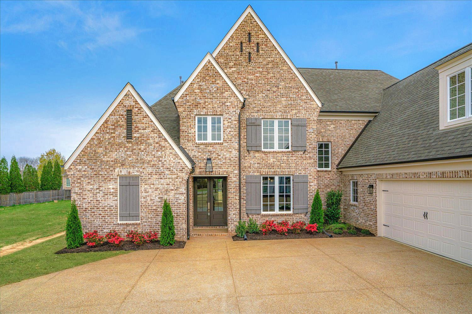 View of front of home featuring brick siding, concrete driveway, a garage, roof with shingles, and a front yard