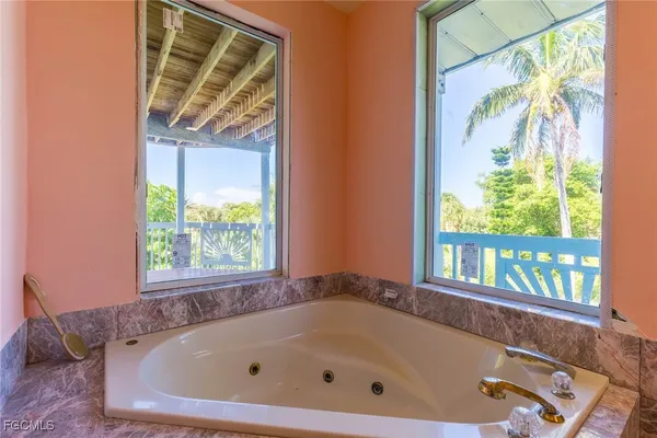 a bathroom with bathtub and window
