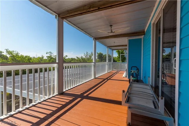 a view of a balcony with a large window and wooden floor
