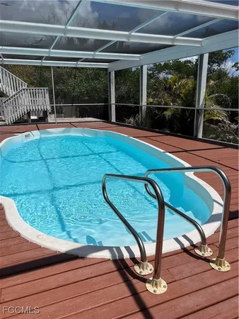 a view of a swimming pool with a porch and furniture