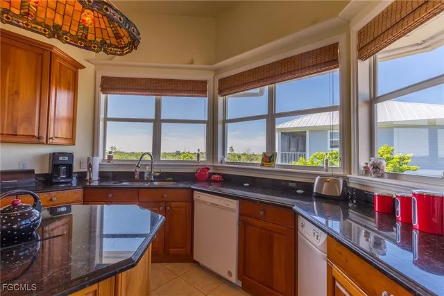 a kitchen with stainless steel appliances granite countertop a sink a stove and a microwave