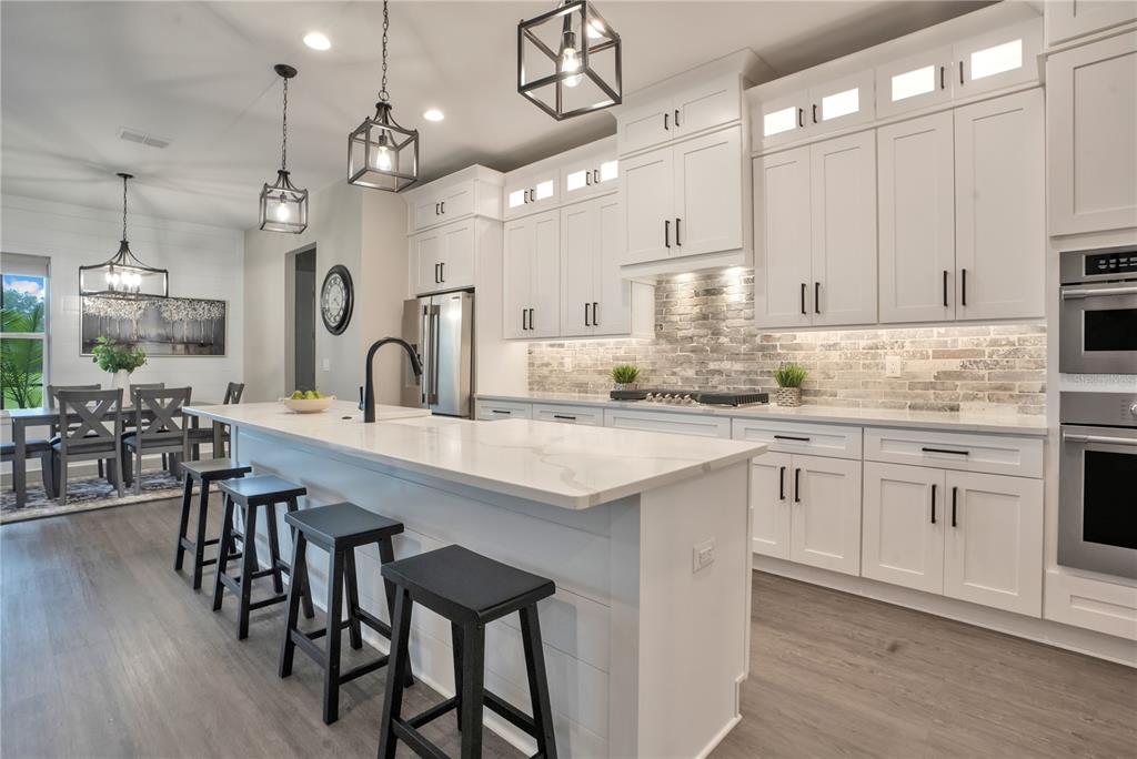 440 Palma Ceia Road Winter Haven, FL 33884 - Photo 12 of 78 a kitchen with kitchen island granite countertop a table chairs sink and cabinets
