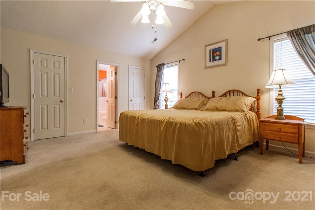 67 Rolling Meadow Road Fletcher, NC 28732 - Photo 24 of 39 a spacious bedroom with a bed and a chandelier