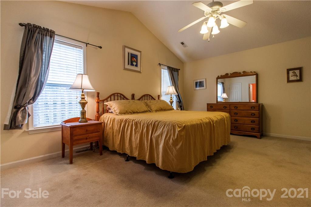 67 Rolling Meadow Road Fletcher, NC 28732 - Photo 25 of 39 a spacious bedroom with a bed and a chandelier
