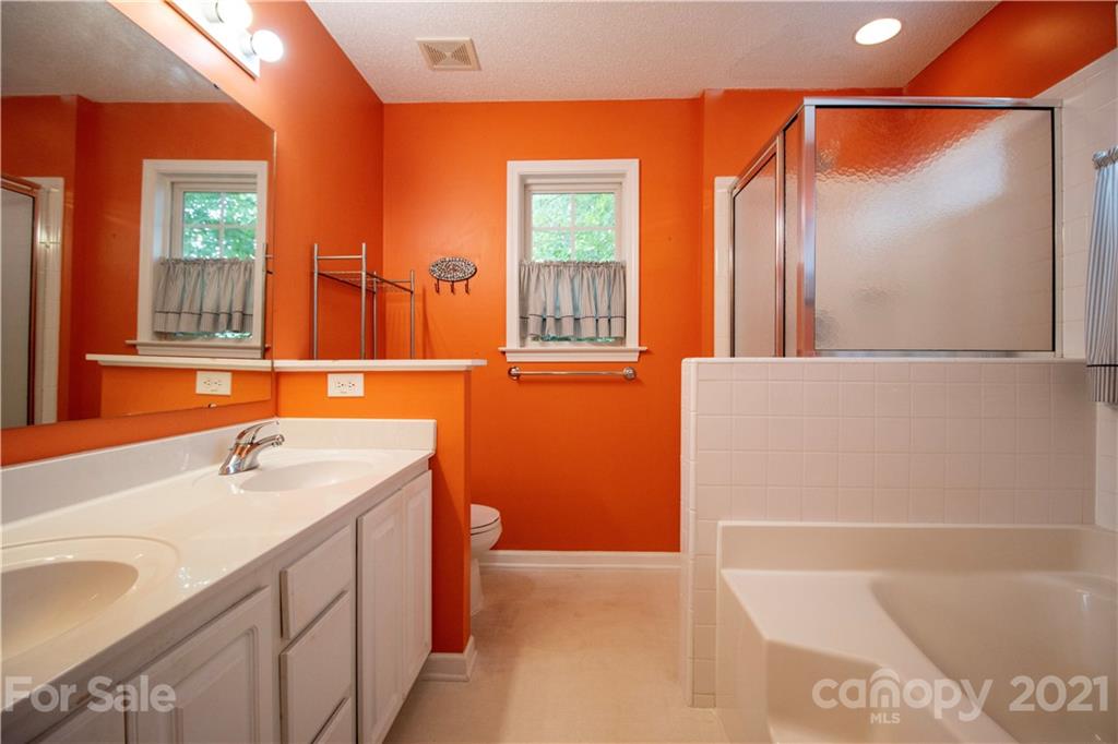 67 Rolling Meadow Road Fletcher, NC 28732 - Photo 28 of 39 a bathroom with a sink a mirror and a bathtub