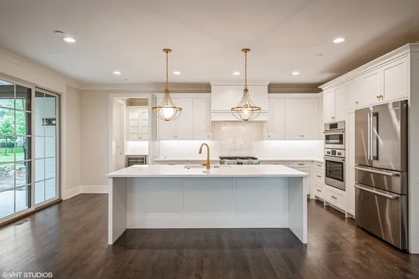 a kitchen with kitchen island white cabinets and stainless steel appliances