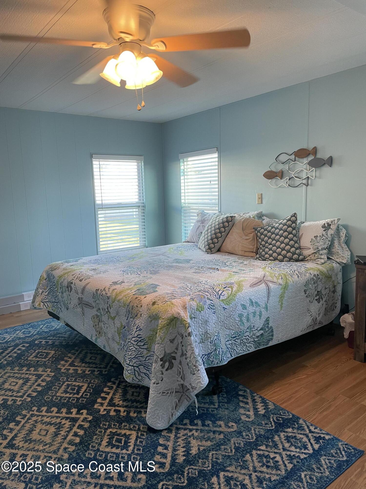 505 Puffin Drive Barefoot Bay, FL 32976 - Photo 3 of 8 a bedroom with a bed and a chandelier