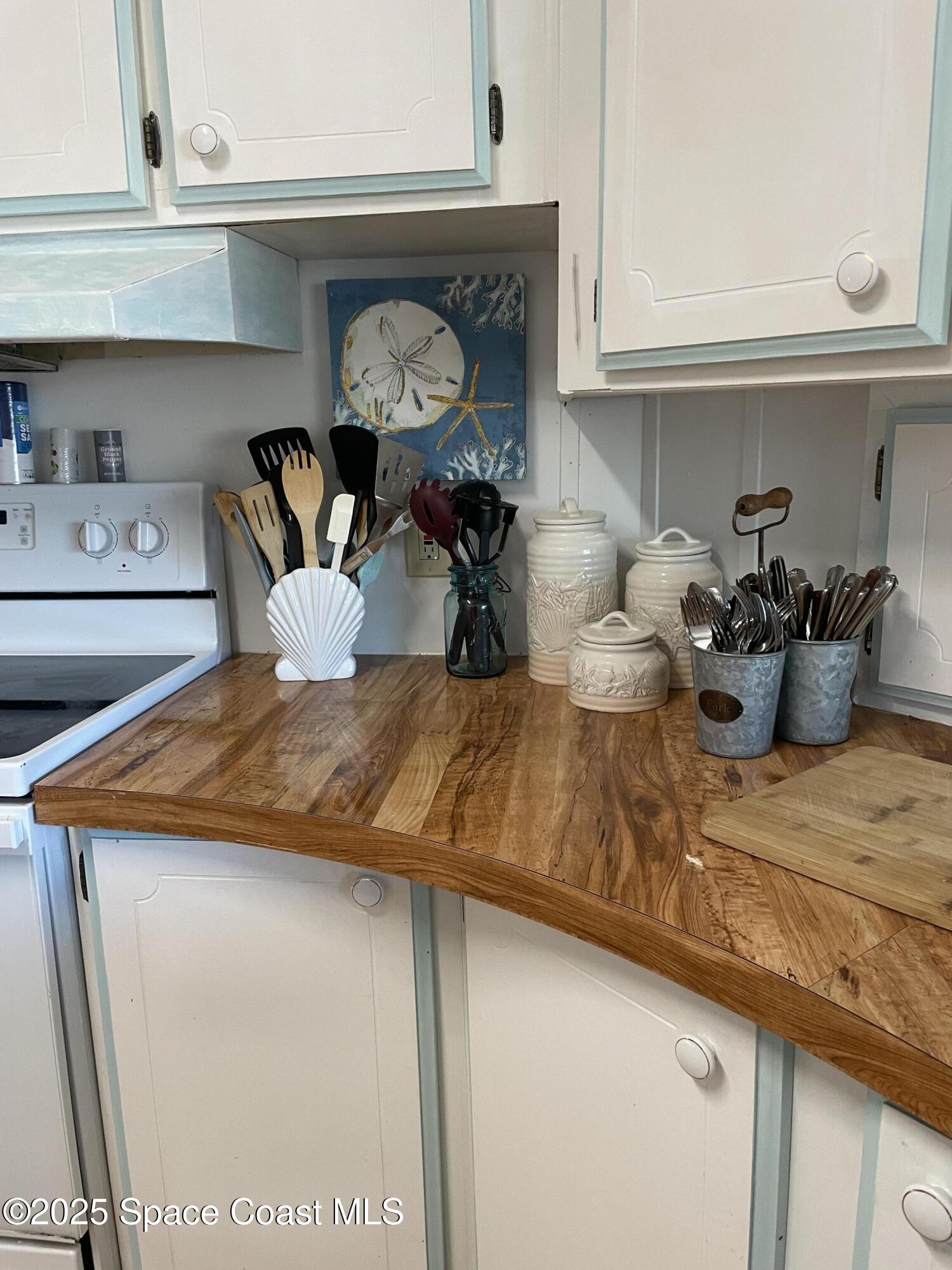 505 Puffin Drive Barefoot Bay, FL 32976 - Photo 5 of 8 a kitchen with a stove and cabinets