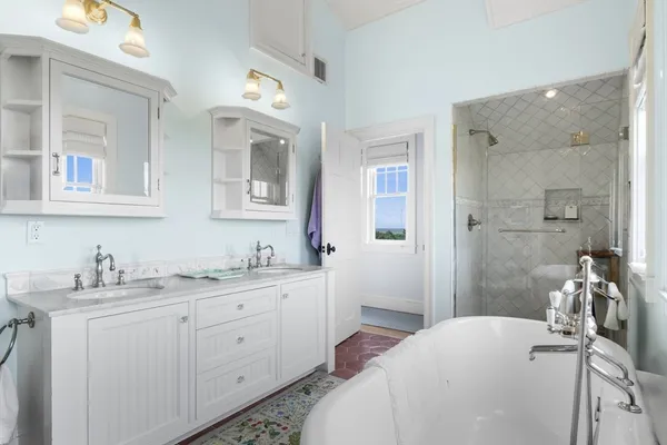 a en suite bathroom with a double vanity sink a large mirror a shower and vanity