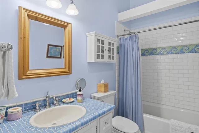 a bathroom with a granite countertop toilet sink and mirror