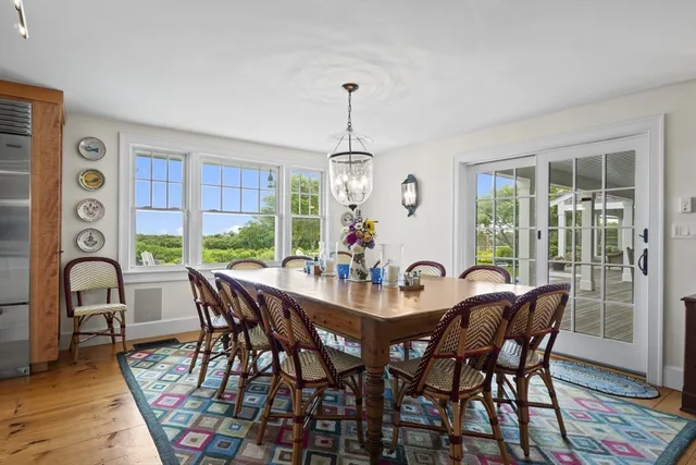 a dining room with furniture a chandelier and wooden floor