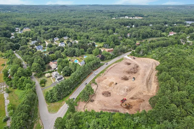 an aerial view of a house with a yard and lake view