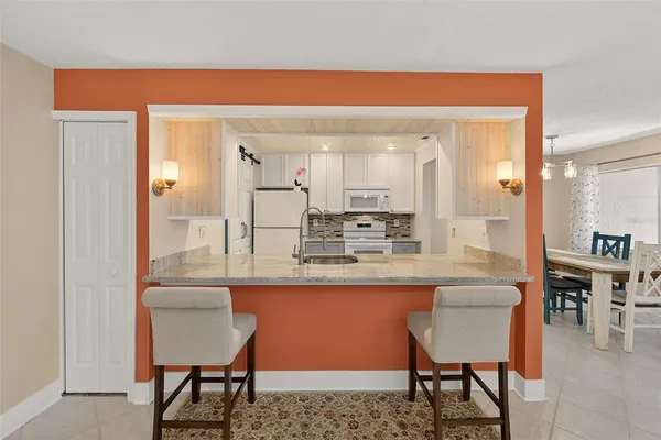 a kitchen with kitchen island a dining table and chairs