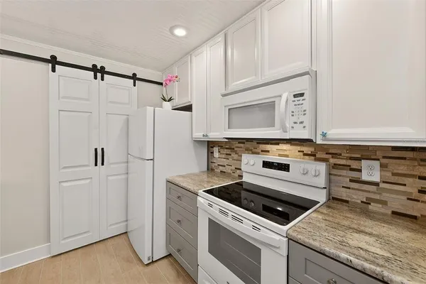 a kitchen with white cabinets and white appliances