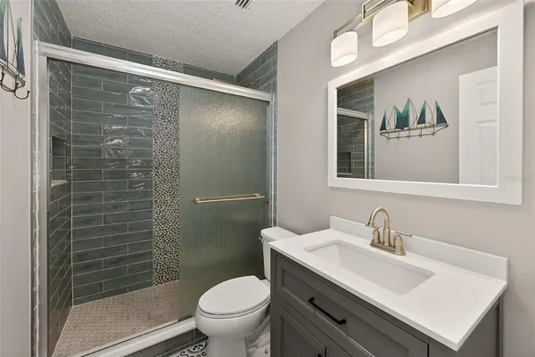 a bathroom with a sink mirror toilet and shower
