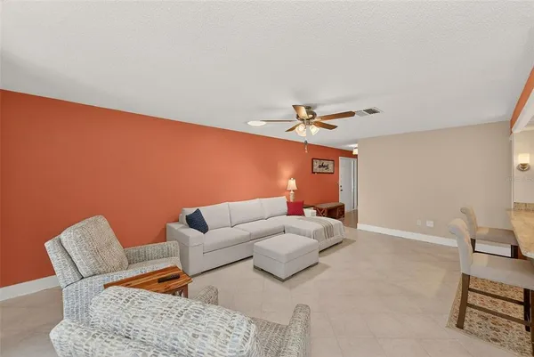 a living room with furniture and a ceiling fan