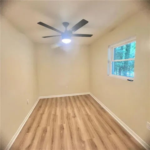 an empty room with a window and a fan