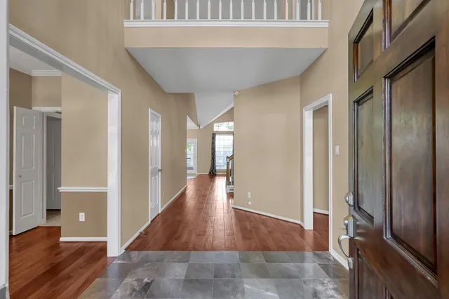 a view of a hallway with wooden floor and staircase