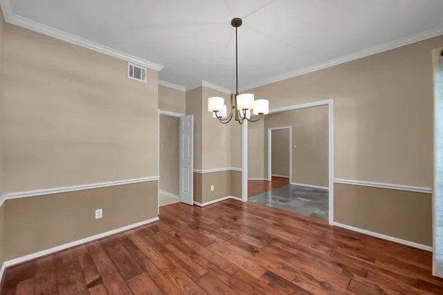 a view of a livingroom with a chandelier fan and wooden floor