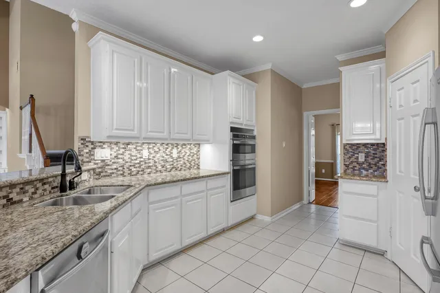 a kitchen with granite countertop a sink and a refrigerator