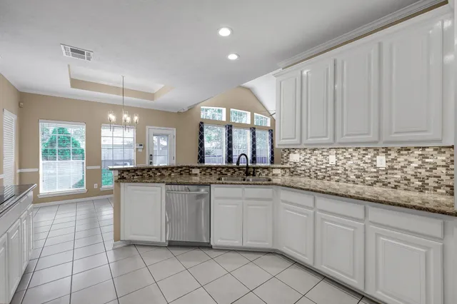 a kitchen with granite countertop white cabinets and white appliances