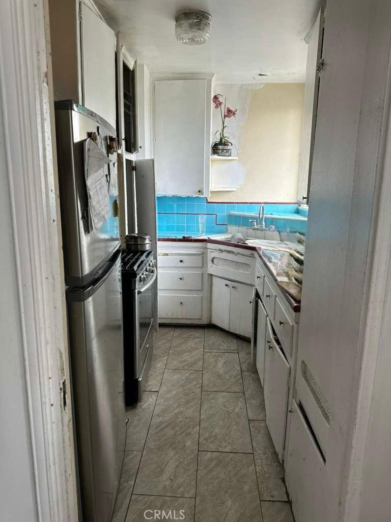 10401 State Street South Gate, CA 90280 - Photo 21 of 21 a kitchen with white cabinets and stainless steel appliances