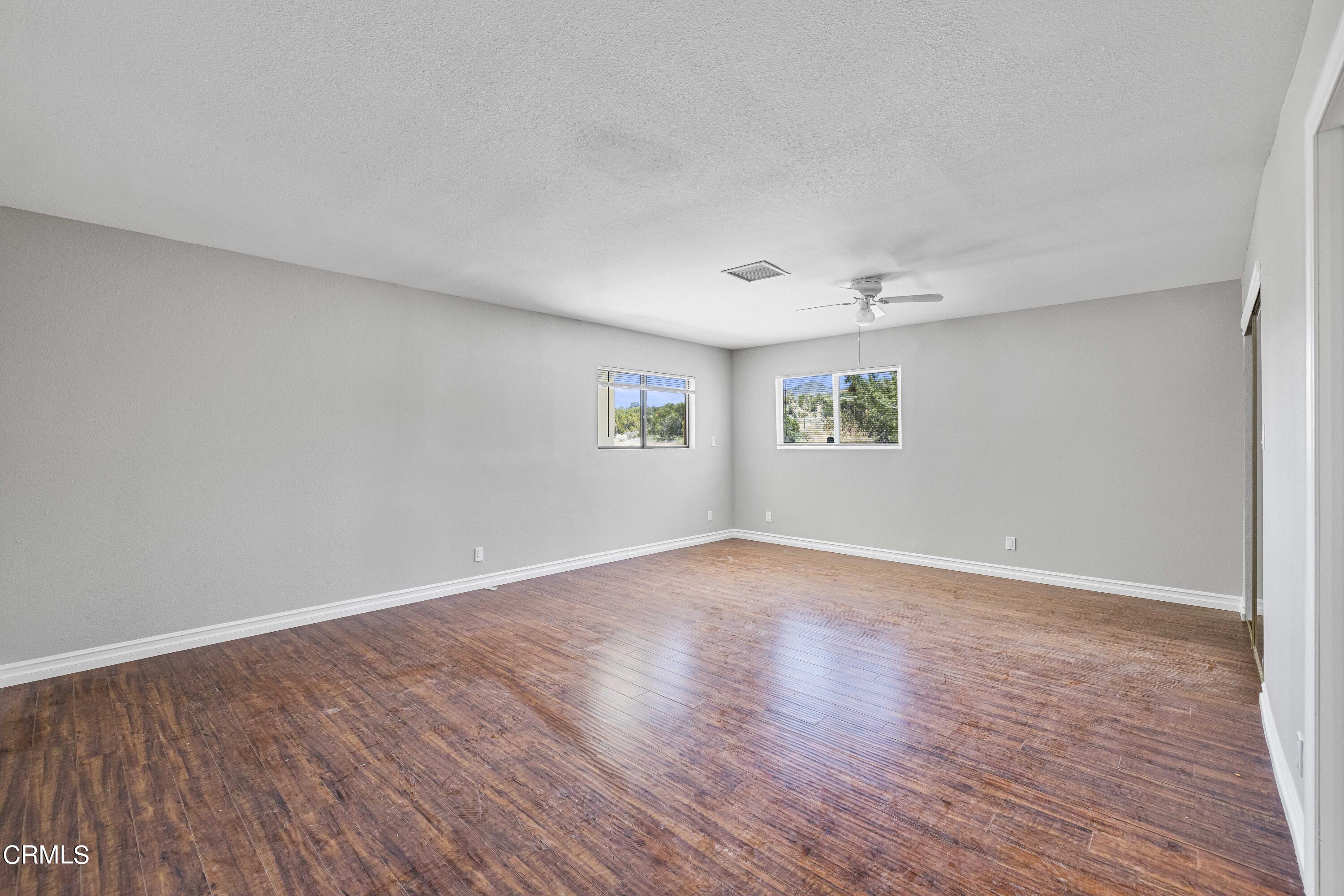 728 Nielson Road Pinon Hills, CA 92372 - Photo 29 of 50 a view of empty room with wooden floor and fan