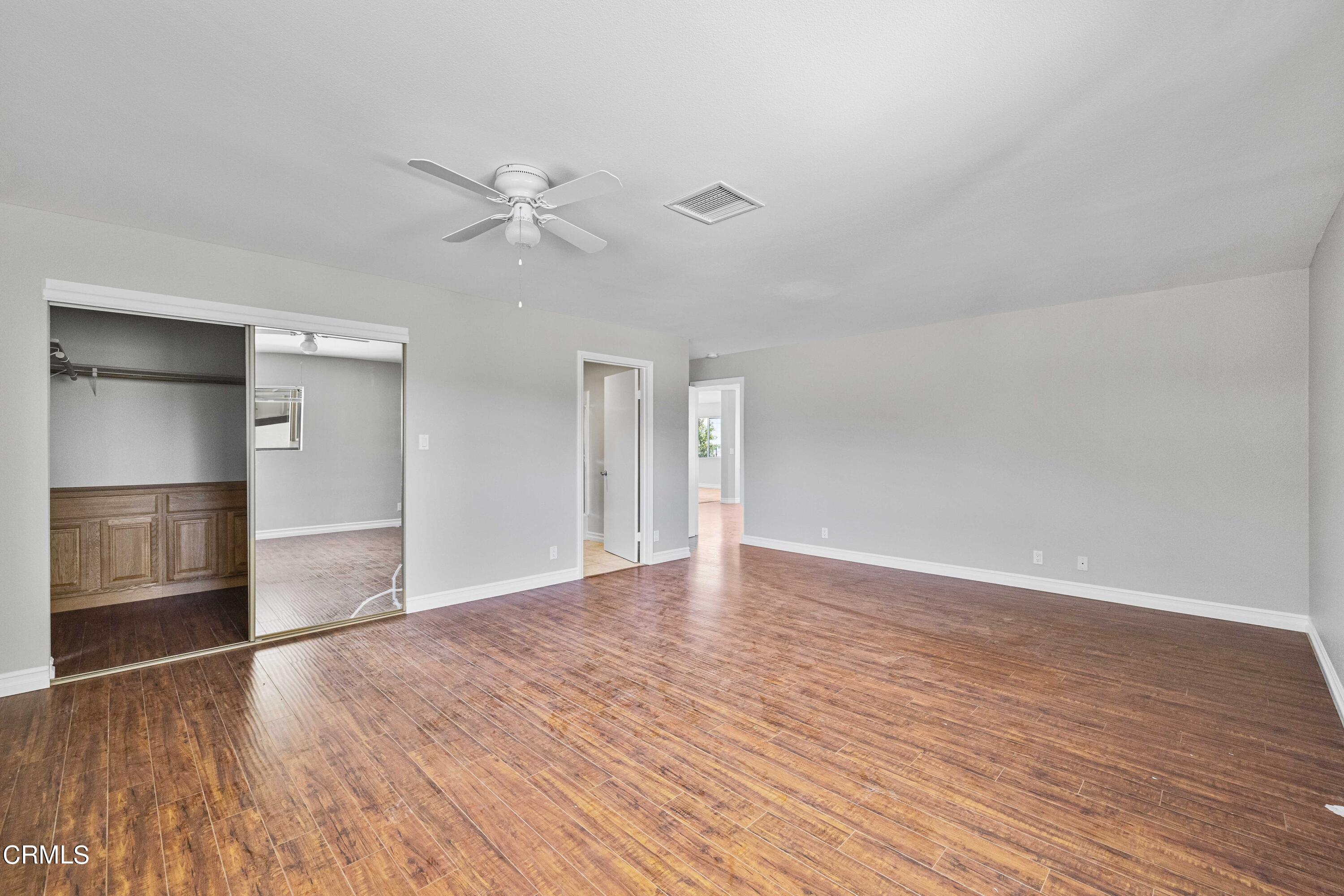 728 Nielson Road Pinon Hills, CA 92372 - Photo 31 of 50 an empty room with wooden floor closet ceiling fan and windows