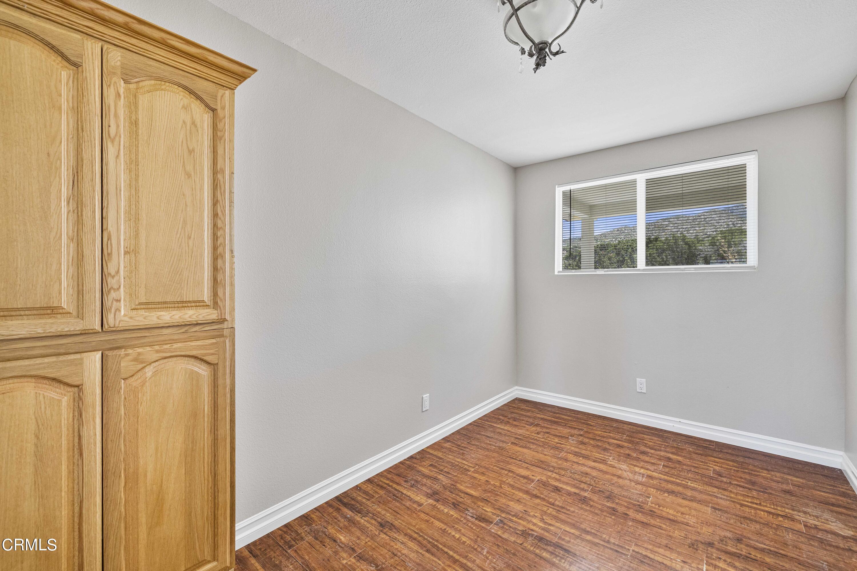 728 Nielson Road Pinon Hills, CA 92372 - Photo 36 of 50 a view of empty room with wooden floor and fan