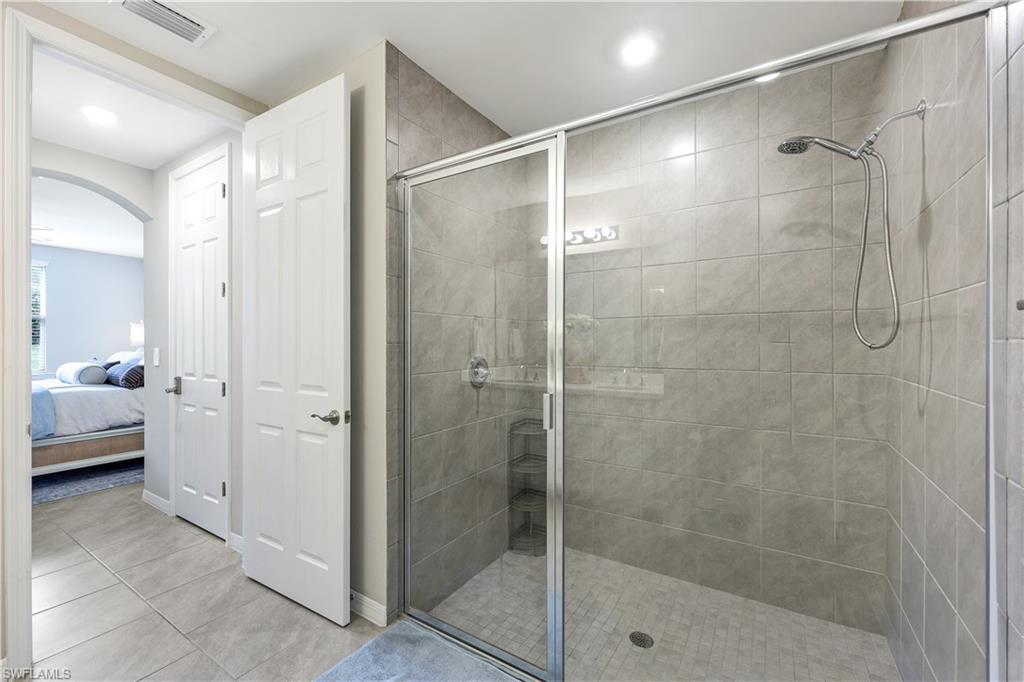 14551 Edgewater Circle Naples, FL 34114 - Photo 15 of 26 Full bath with connected bathroom, a shower stall, light tile patterned floors, and recessed lighting