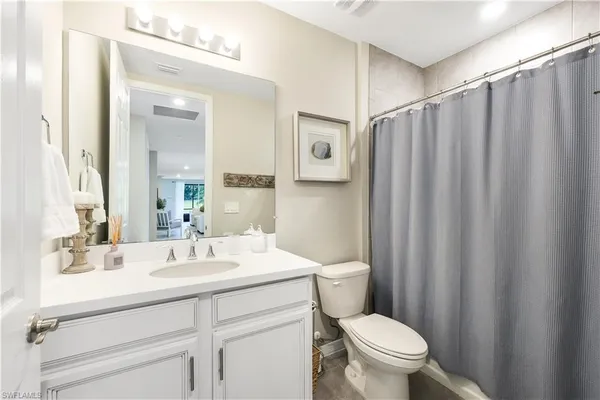 a bedroom with a bed and a flat tv screen on a dresser