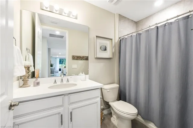 a bedroom with a bed and a flat tv screen on a dresser