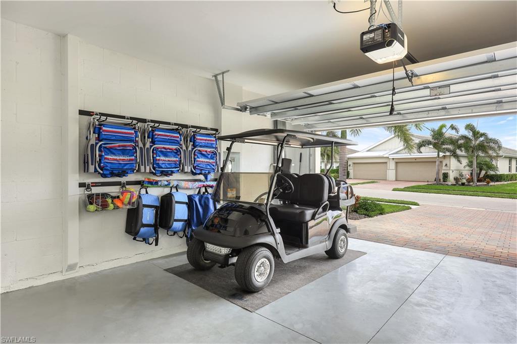 14551 Edgewater Circle Naples, FL 34114 - Photo 19 of 26 Garage with a garage door opener and concrete block wall