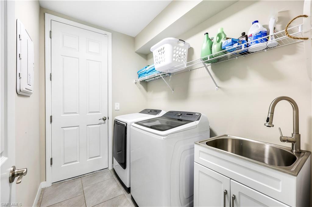 14551 Edgewater Circle Naples, FL 34114 - Photo 20 of 26 Washroom featuring light tile patterned floors, independent washer and dryer, and electric panel