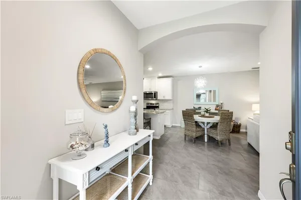 a living room with furniture a mirror and a table