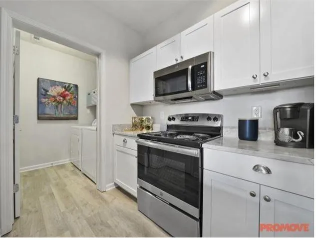 a kitchen with stainless steel appliances granite countertop white cabinets a stove top oven a sink and dishwasher