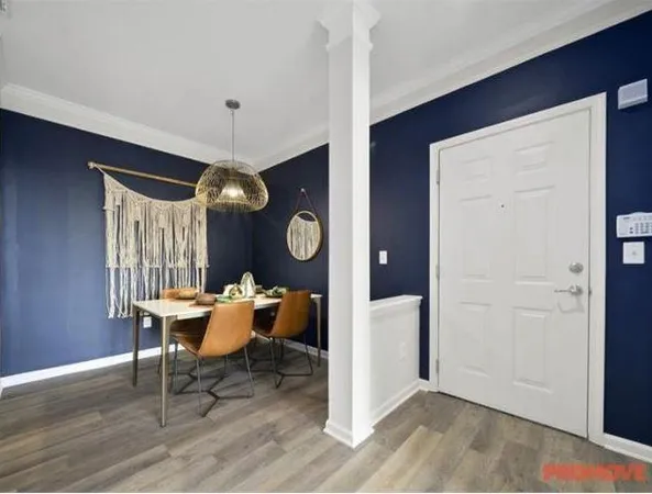 a dining room with wooden floor a chandelier a wooden table and chairs