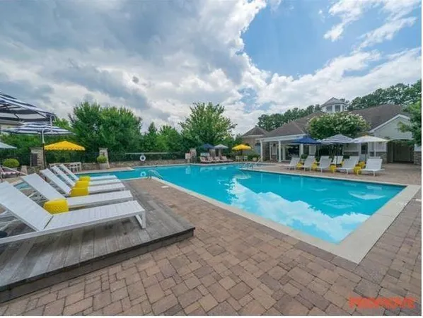 swimming pool view with a sitting space and garden view