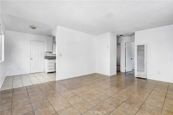 a view of an empty room with a kitchen