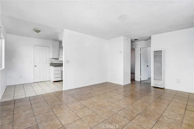 a view of an empty room with a kitchen