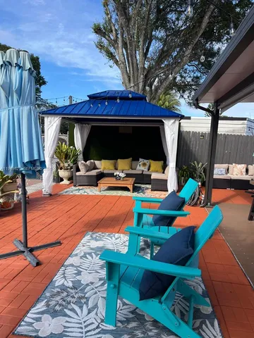 a view of a backyard with table and chairs under an umbrella with a small yard