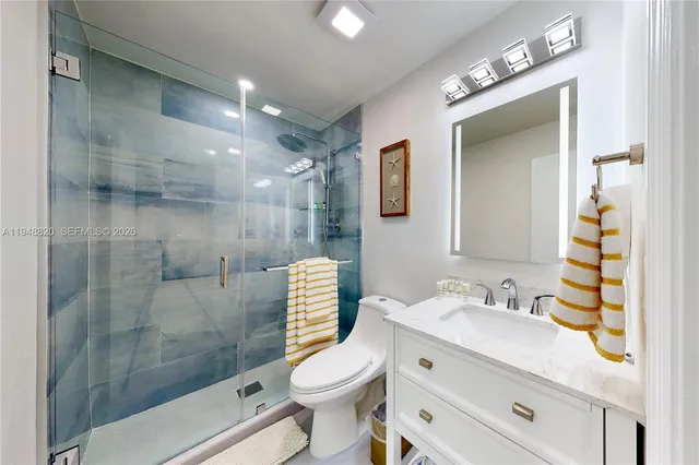 a bathroom with a sink toilet vanity and shower