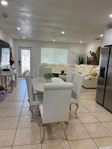 a living room with furniture a dining table and a window