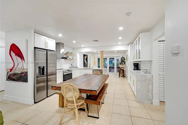 a large kitchen with stainless steel appliances kitchen island granite countertop a refrigerator and cabinets