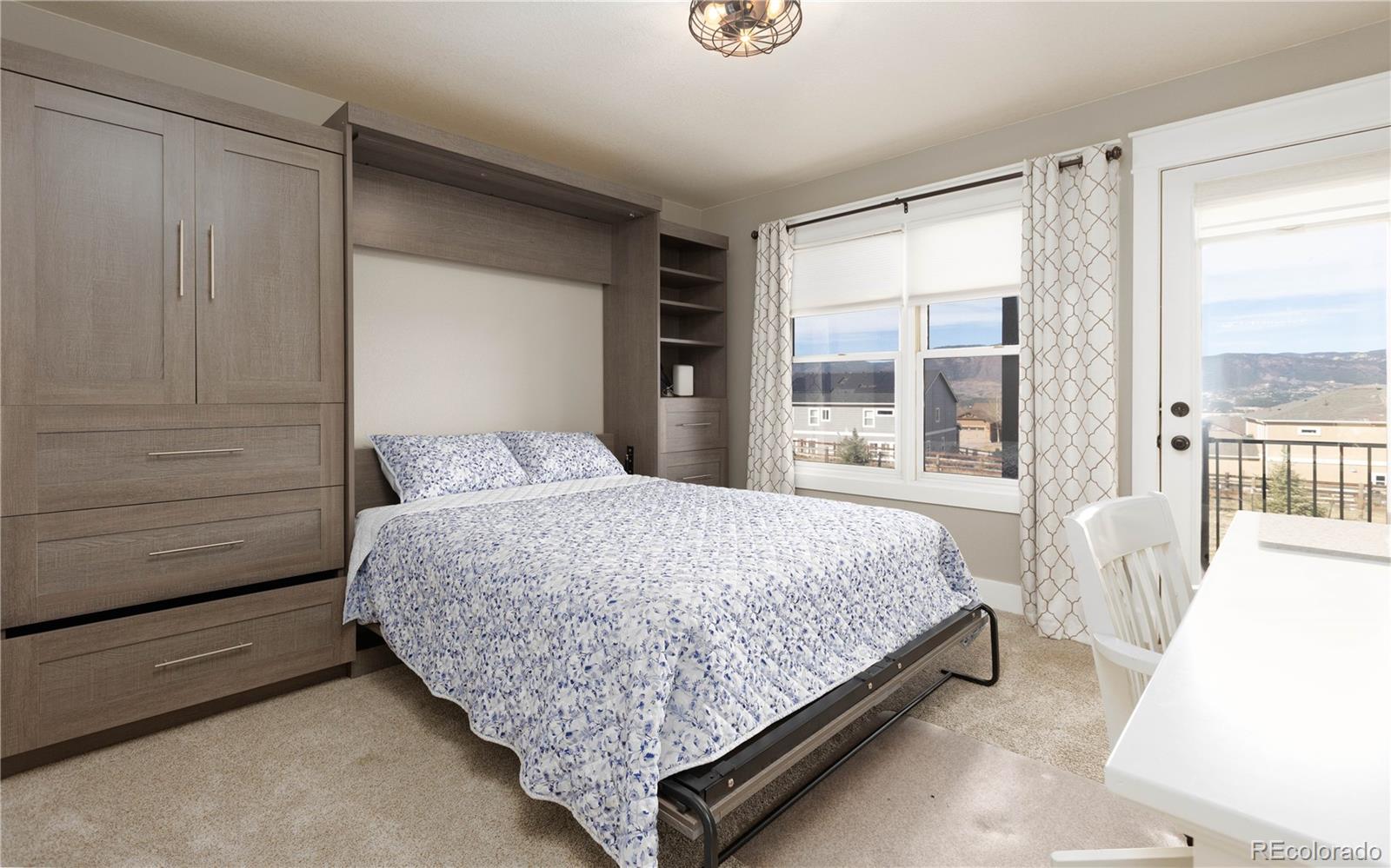 17840 New London Road Monument, CO 80132 - Photo 17 of 47 a bedroom with a large bed and a large window